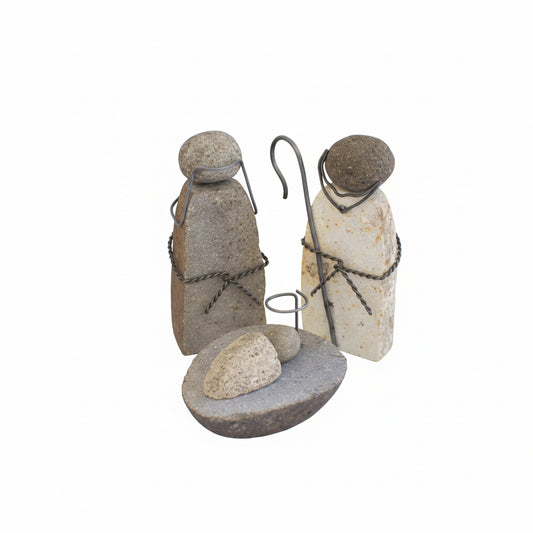 Three stone nativity figures with a shepherd's crook on a white background with greenery and berries.